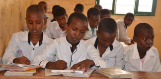 © UNICEF Somalia/2017/Sarman Mohamed, second from the left, flanked by his schoolmates in their classroom at Omar bin Khataab primary school in Berbera, which is supported by the Joint Programme on Local Governance and Decentralised Service Delivery (JPLG).