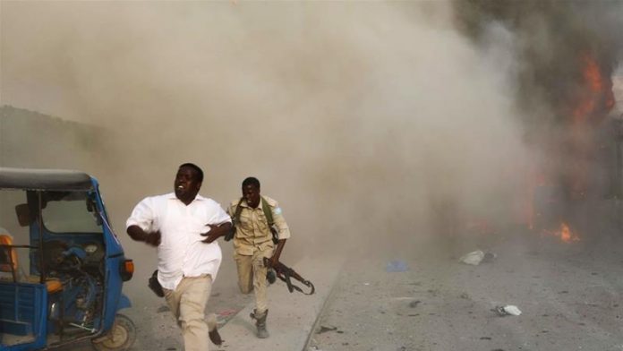 Security officers run from the scene of the blast [Feisal Omar/Reuters]