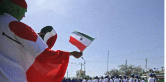 People wave flags as soldiers and other military personnel of Somalia's breakaway territory of Somaliland march past during an Independence Day celebration parade in the capital, Hargeisa on May 18, 2016. MOHAMED ABDIWAHAB/AFP VIA GETTY IMAGES