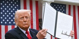US President Donald Trump holds a signed executive order after delivering remarks on reciprocal tariffs during an event in the Rose Garden entitled “Make America Wealthy Again” at the White House in Washington, DC, on April 2, 2025. (Photo by SAUL LOEB / AFP)